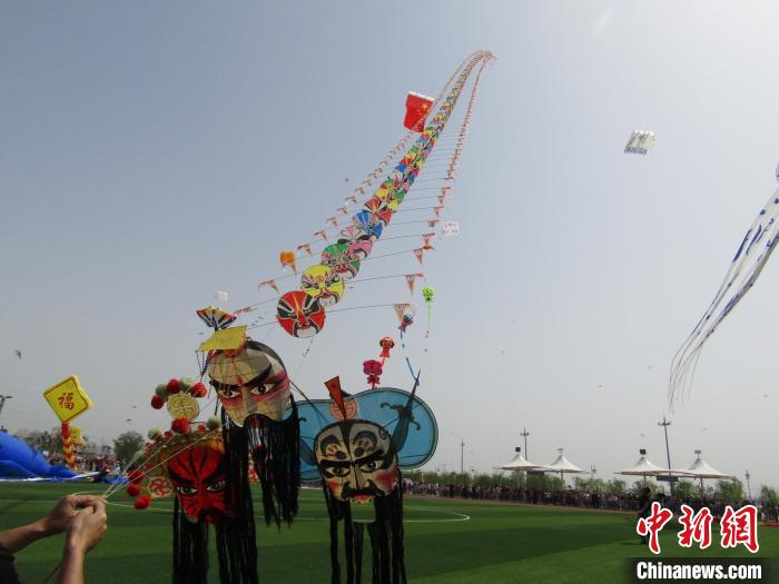长达48米的“刘关张桃园三结义”风筝飞到空中，该风筝包括了108个不同的川剧脸谱。邓静供图
