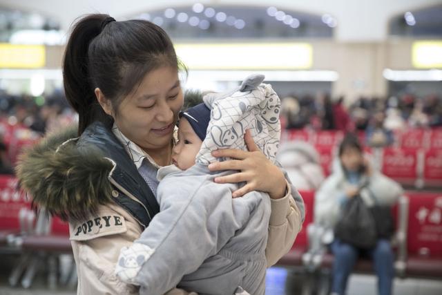 资料图片：一位母亲抱着孩子返乡。新华社记者张涛摄