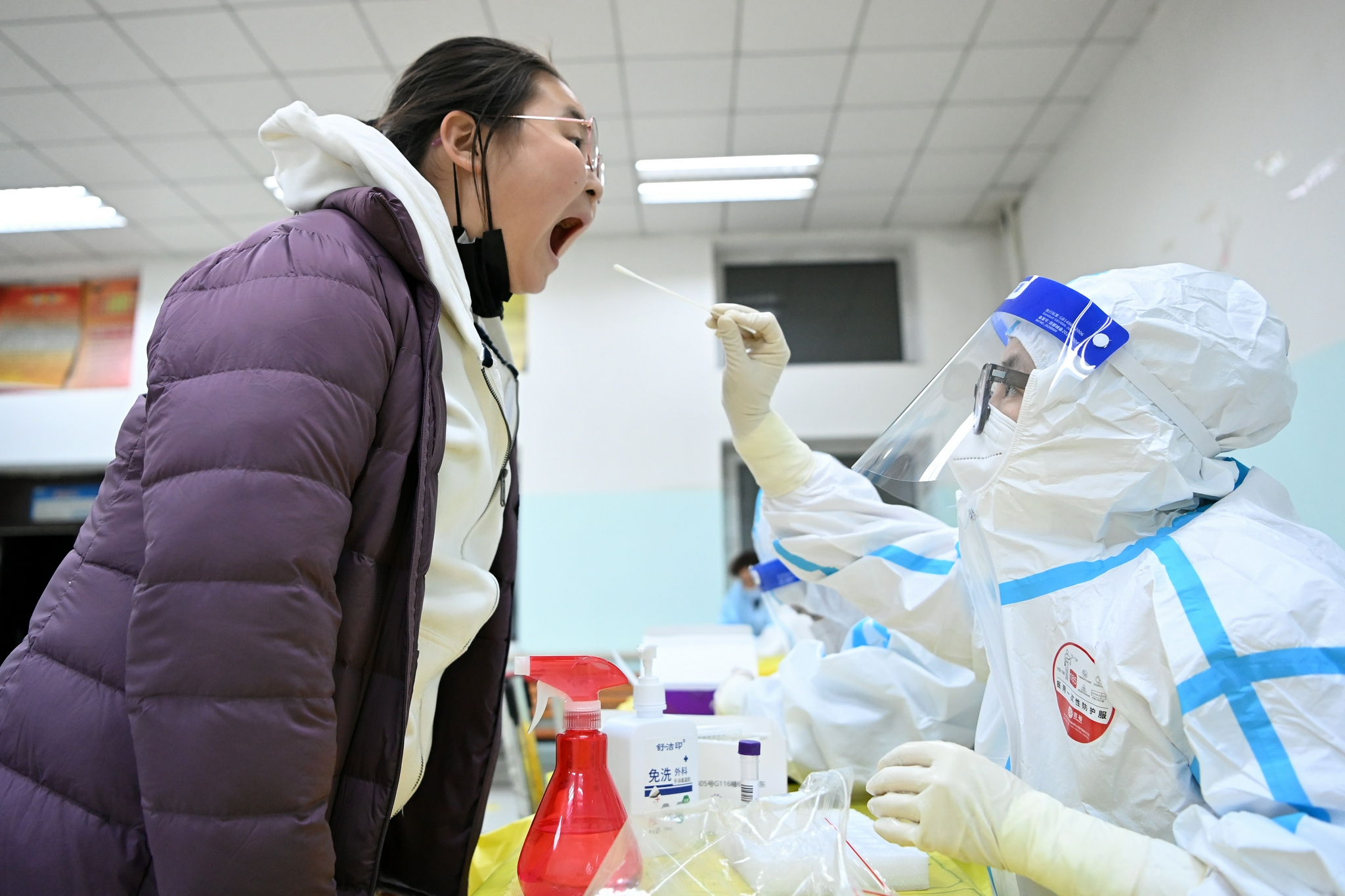 10月30日,工作人员在哈尔滨市香坊区一处核酸采样点进行采样.