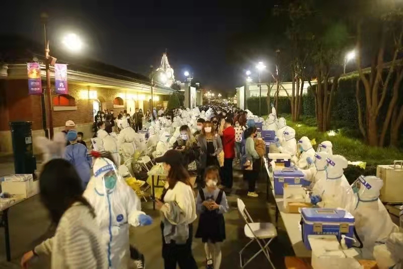 10月31日晚，上海迪士尼乐园内，医护人员正在为游客做核酸检测。来源：上海发布
