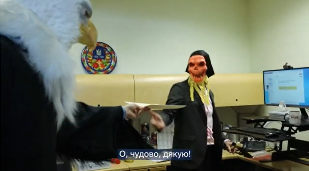 头戴白头海雕面具的男子向另外一位同事转交文件，图源：俄媒视频截图