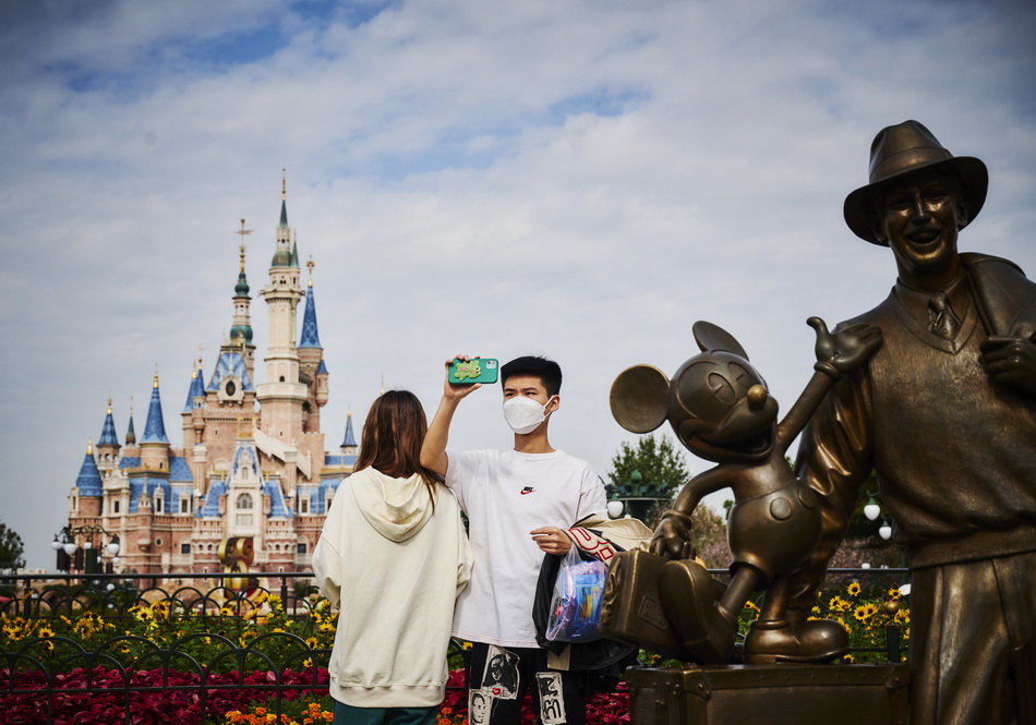 2021年11月3日，游客在上海迪士尼乐园故事家雕像前自拍。