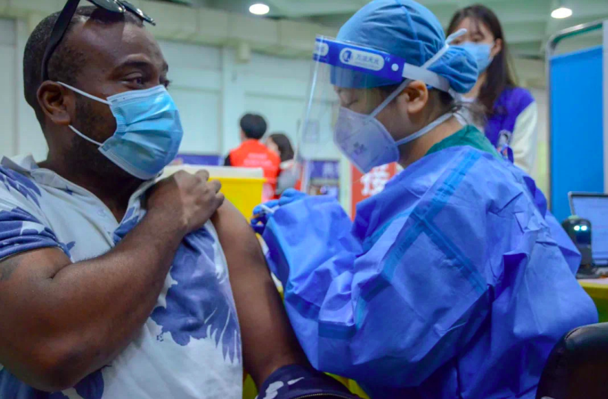 高校师生打加强针，现场有位忙碌的留学生“红马甲”休闲区蓝鸢梦想 - Www.slyday.coM