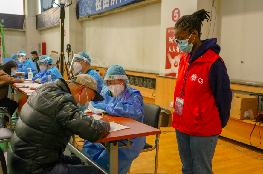 高校师生打加强针，现场有位忙碌的留学生“红马甲”休闲区蓝鸢梦想 - Www.slyday.coM