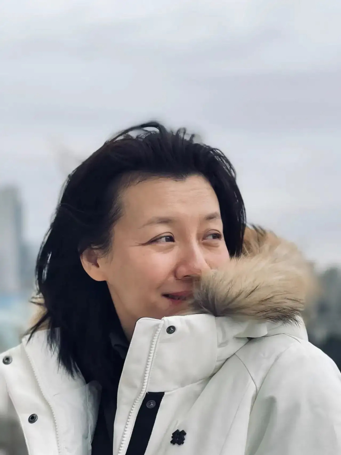 刘琳素颜面对镜头微笑,照片中的刘琳穿着白色羽绒服,头发自然披散