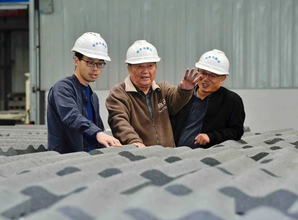 ▲11月4日，王其昌（中）在声屏障吸声板生产厂与技术人员交流生产情况