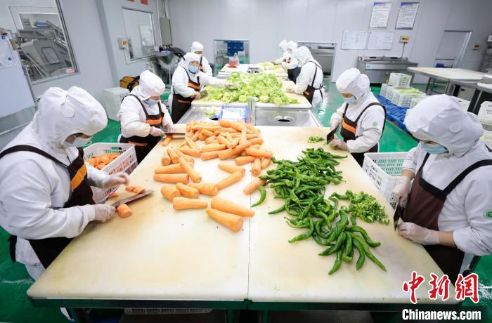 图为在合作社净菜加工车间,工作人员对蔬菜进行加工. 宋敏涛 摄