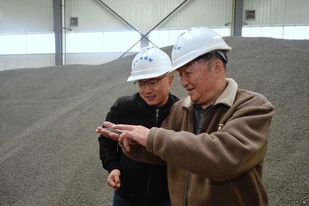 ▲11月4日，王其昌（右）在声屏障吸声板生产厂与技术人员交流