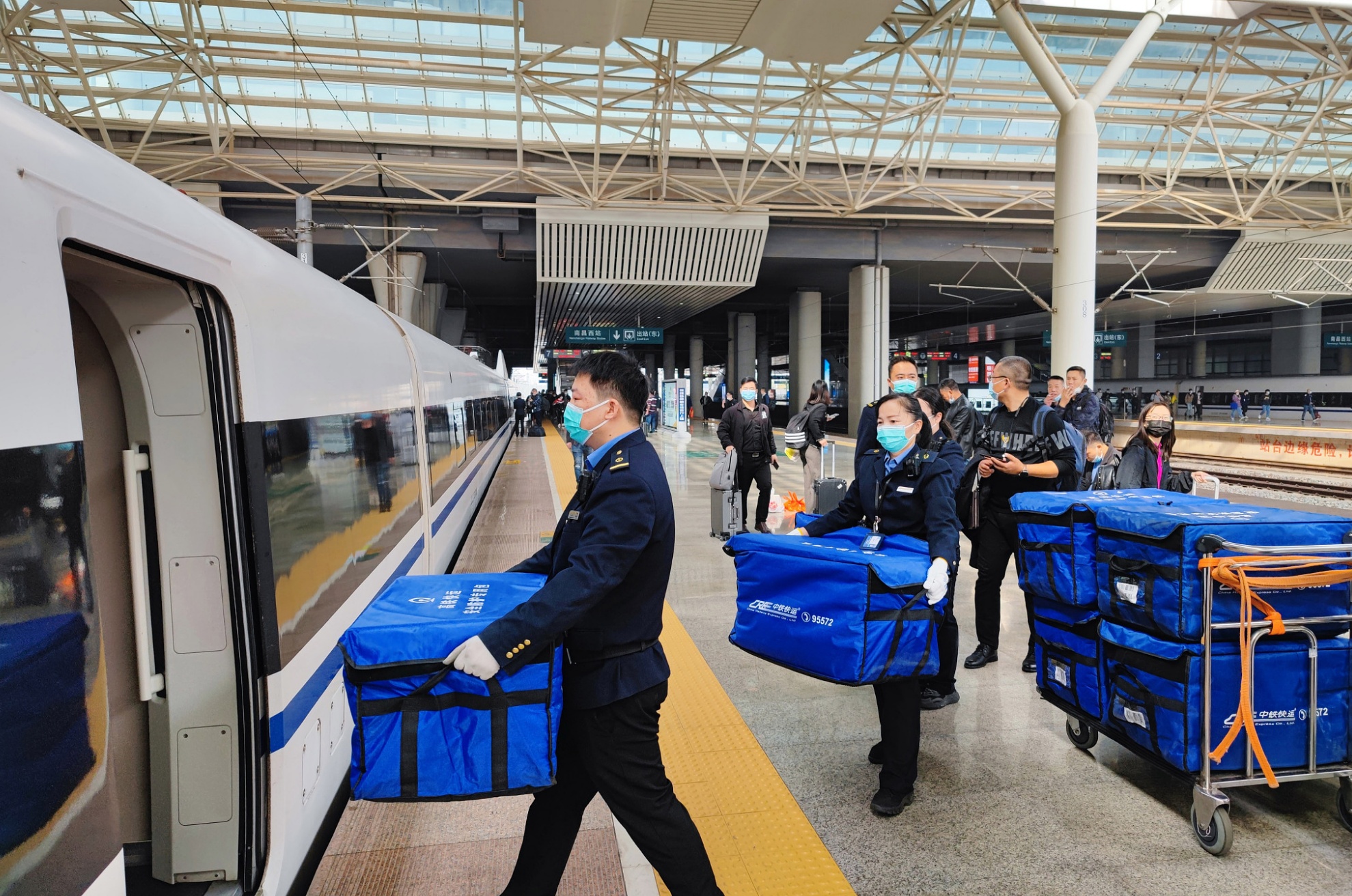 资料图:2021年11月1日,中铁快运南昌西站营业部职工正在往g488次载客