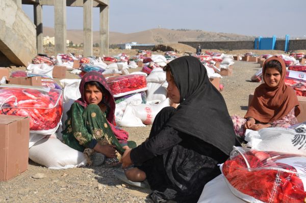 11月9日，在阿富汗霍斯特省，孩子们坐在援助物资旁。 新华社发