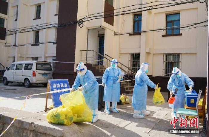 资料图：青海省西宁市火电小区封控区，医护人员为居民上门检测核酸后，进行消杀。中新社记者 马铭言 摄