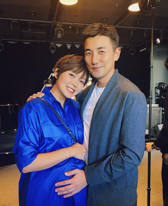 tvb小生洪永城与挺孕肚的太太恩爱合影 用手摸孕肚露出幸福笑容