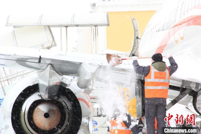 哈尔滨机场工作人员为机身进行除雪。哈尔滨机场提供