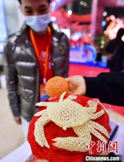 图为11月23日，2021福建旅游交易会上福州高楼米线作品螃蟹和桔子吸引参观者眼球。　张斌 摄