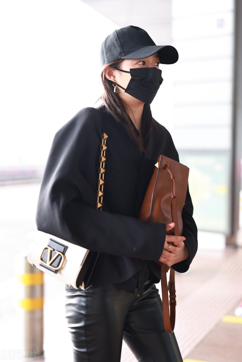 关晓彤穿黑色短外套搭配黑色皮裤,脚踩黑色短靴戴棒球帽帅气十足