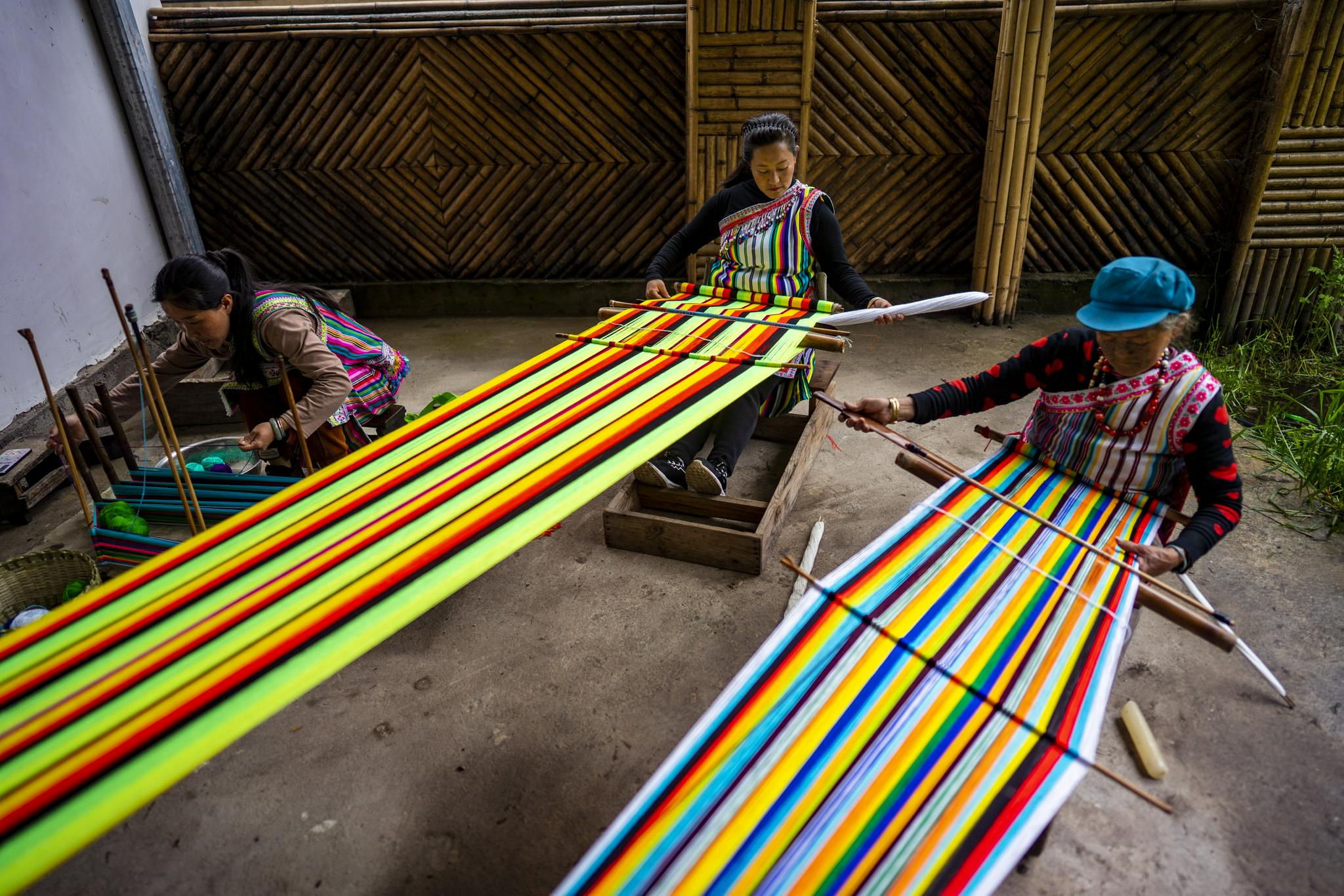 李玉花(中)和亲友在纺织独龙毯(摄于5月21日).