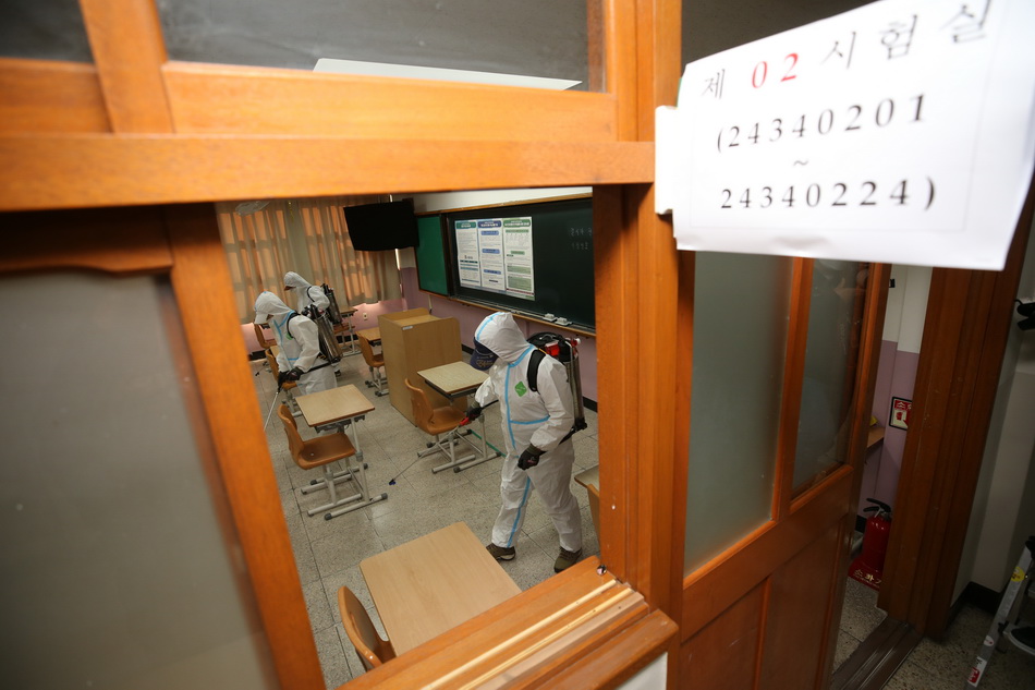  当地时间2021年11月16日，韩国大邱，高考两天前，防疫人员在考场进行消毒作业。