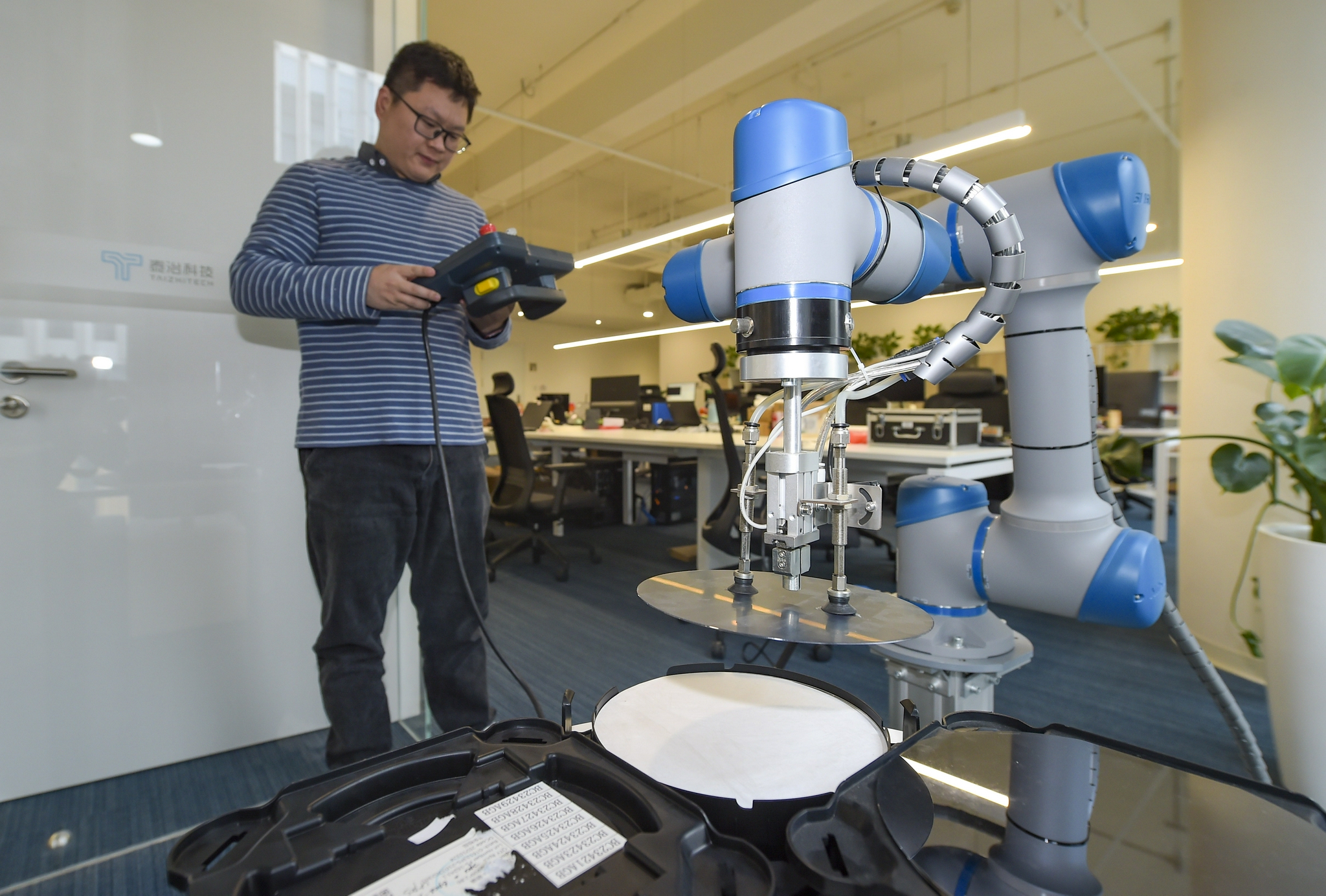 (泰治科技研发人员使用6轴工业机械手对晶圆进行搬运装盒操作)