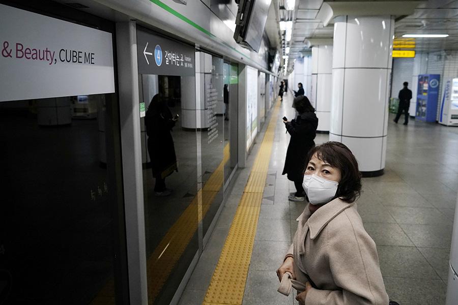 2020年3月1日,韩国首尔,乘客戴着口罩等待地铁列车.