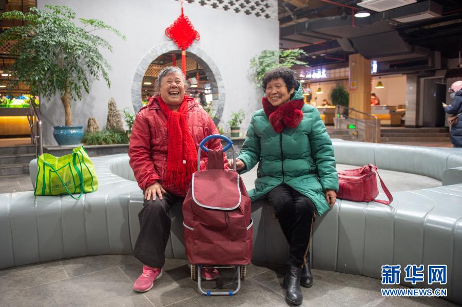  1月5日，在改造完毕的嘉兴市南湖区杨柳湾幸福里菜市场，两名老人在休息区休息。新华社发（江汉 摄）