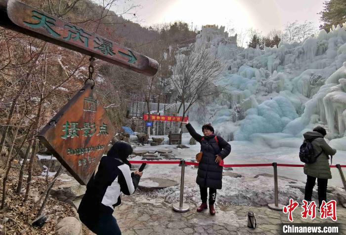 图为游客在九如山风景区的冰瀑前游赏拍照。赵晓 摄