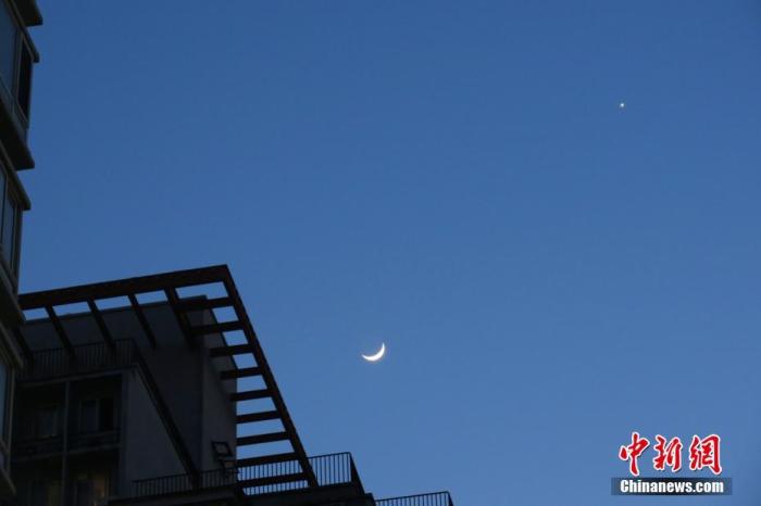 资料图:北京,天气晴好,太阳落山之后,天宇“金星合月”天文景观清晰可见。中新社记者 孙自法 摄