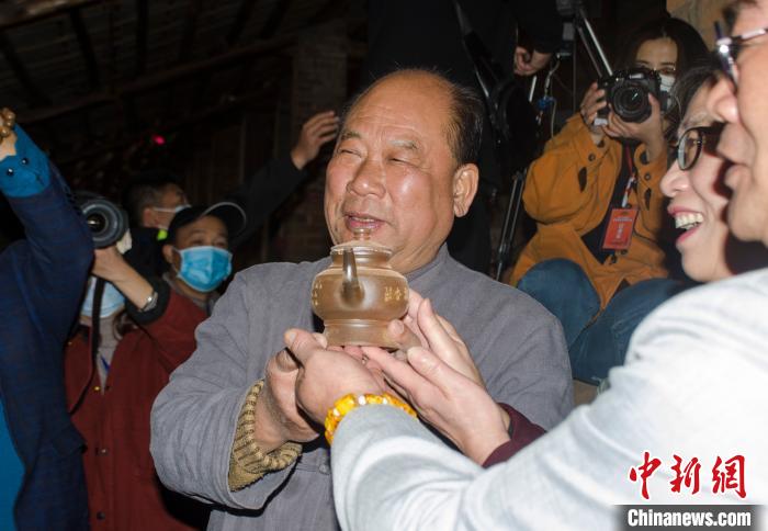 国家级非遗代表性传承人——李人帡展示刚出窑的坭兴陶茶壶.