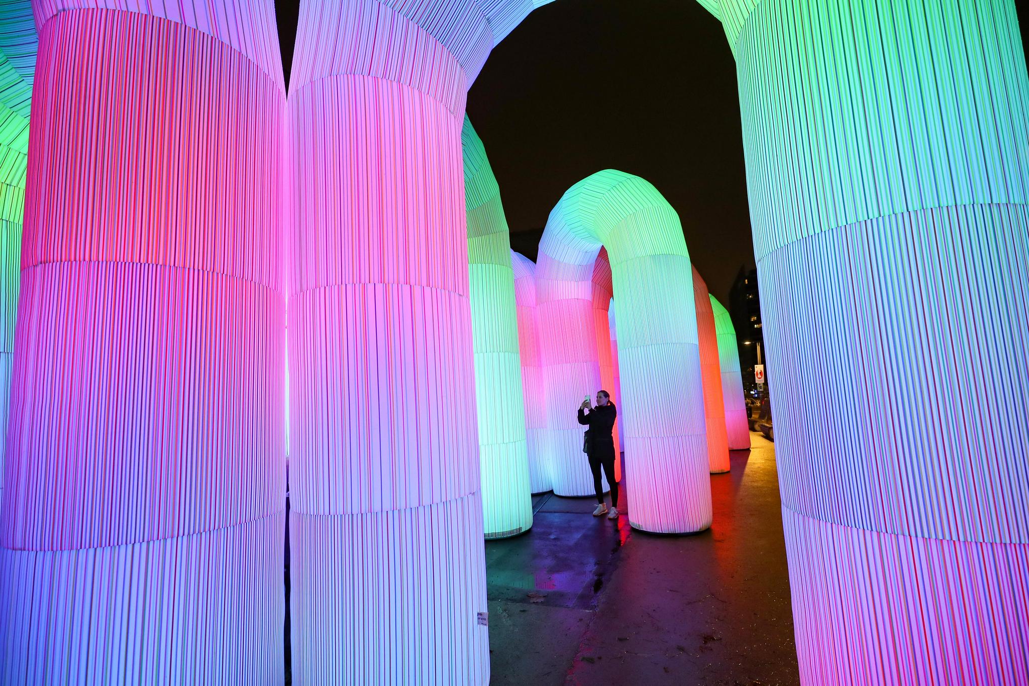 11月30日,游客在比利时布鲁塞尔的舒曼广场欣赏灯光艺术装置"天空