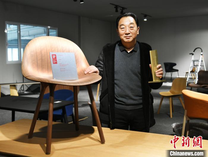 图为产业园内的一家公司负责人展示获得德国IF设计金奖的椅子。宋敏涛 摄