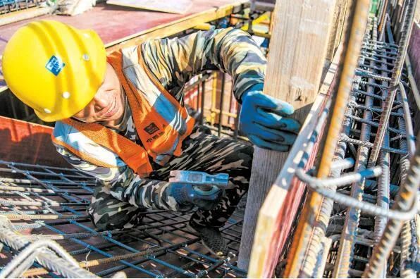 在东寨新居二期项目施工现场,工人忙着安装浇筑用的模板.陈长宇 摄