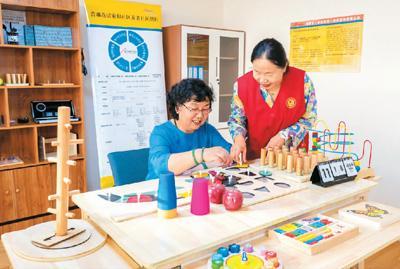 近年来，内蒙古自治区呼和浩特市大力开展居家和社区养老服务项目建设，让老人们乐享晚年。图为12月3日，在呼和浩特市一家社区养老服务中心，志愿者为老人进行能力评估。丁根厚摄（人民视觉）