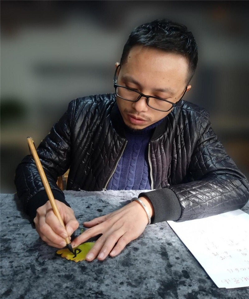 中国书法家协会会员廖红兵在银杏叶上创作(央广网发 杨华军摄)