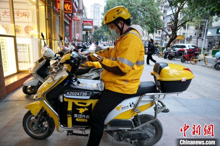 美团外卖骑手程亮正在忙碌着送餐. 叶秋云 摄