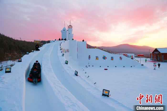 游客从雪堡顶部滑道一滑而下。吕阳 摄