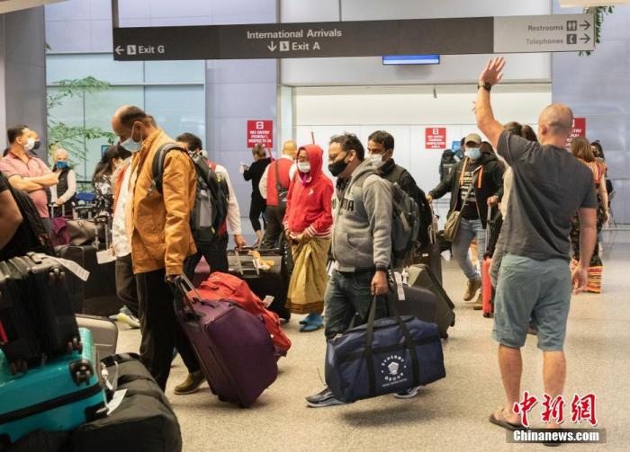 当地时间11月8日，旅客抵达美国加州旧金山国际机场的国际航班到达区域。美国8日起放宽入境限制，允许完成新冠疫苗全程接种的外国旅客乘坐国际航班或通过水陆口岸入境。 中新社记者 刘关关 摄