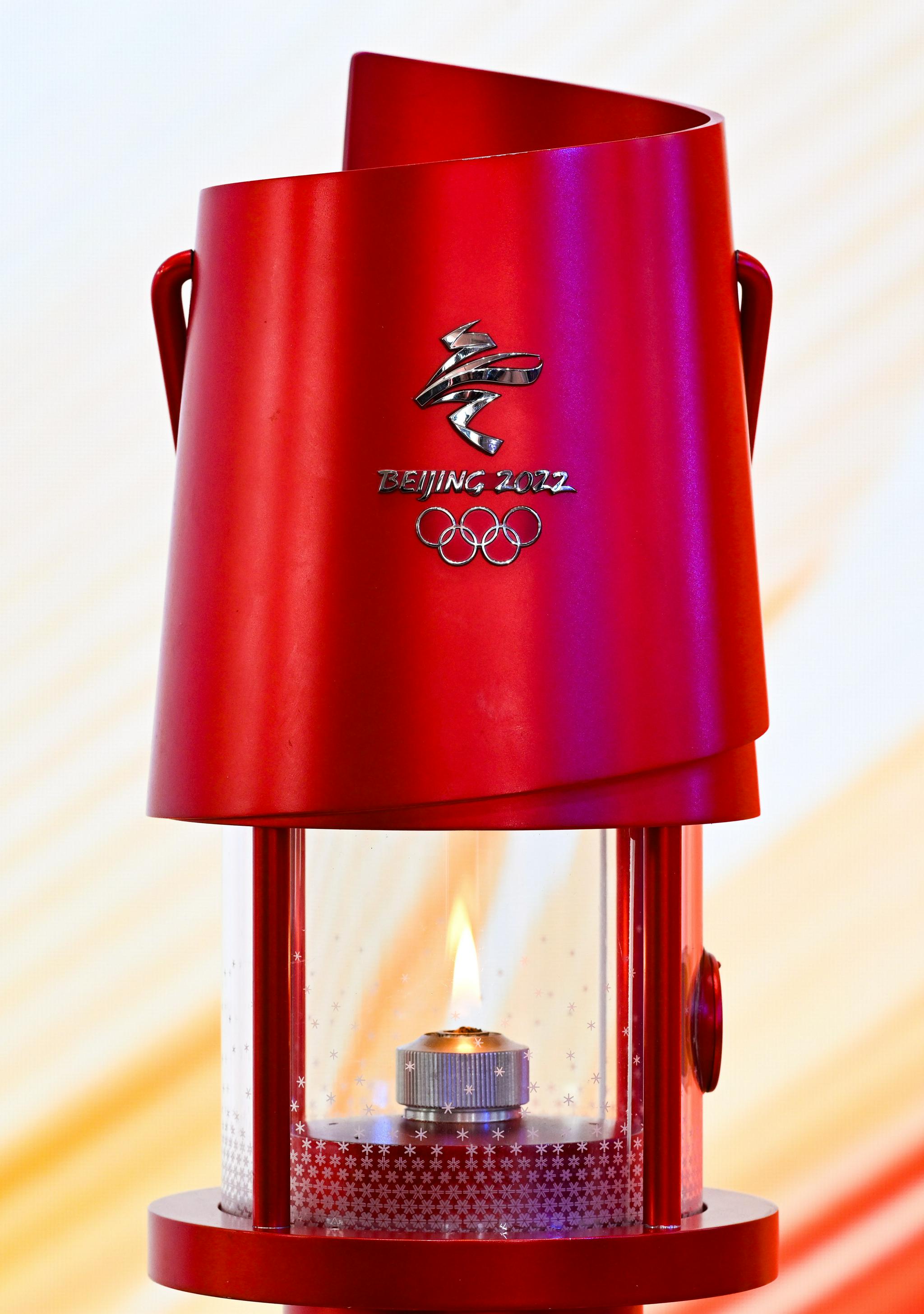 12月16日,护卫人员将北京冬奥会火种灯,火炬放在展示台上.