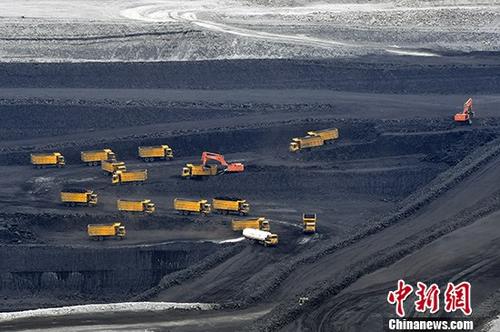资料图：大型运输车辆正在矿坑中忙着转运原煤。中新社记者 刘新 摄