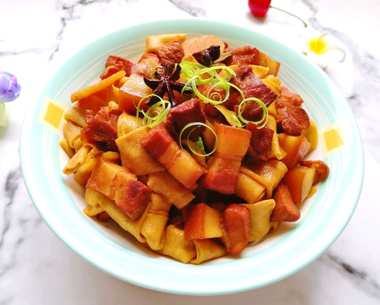 将豆腐皮打成结肉烧肉一起炖制,能够吸收红烧肉中的油脂,使这道菜鲜香