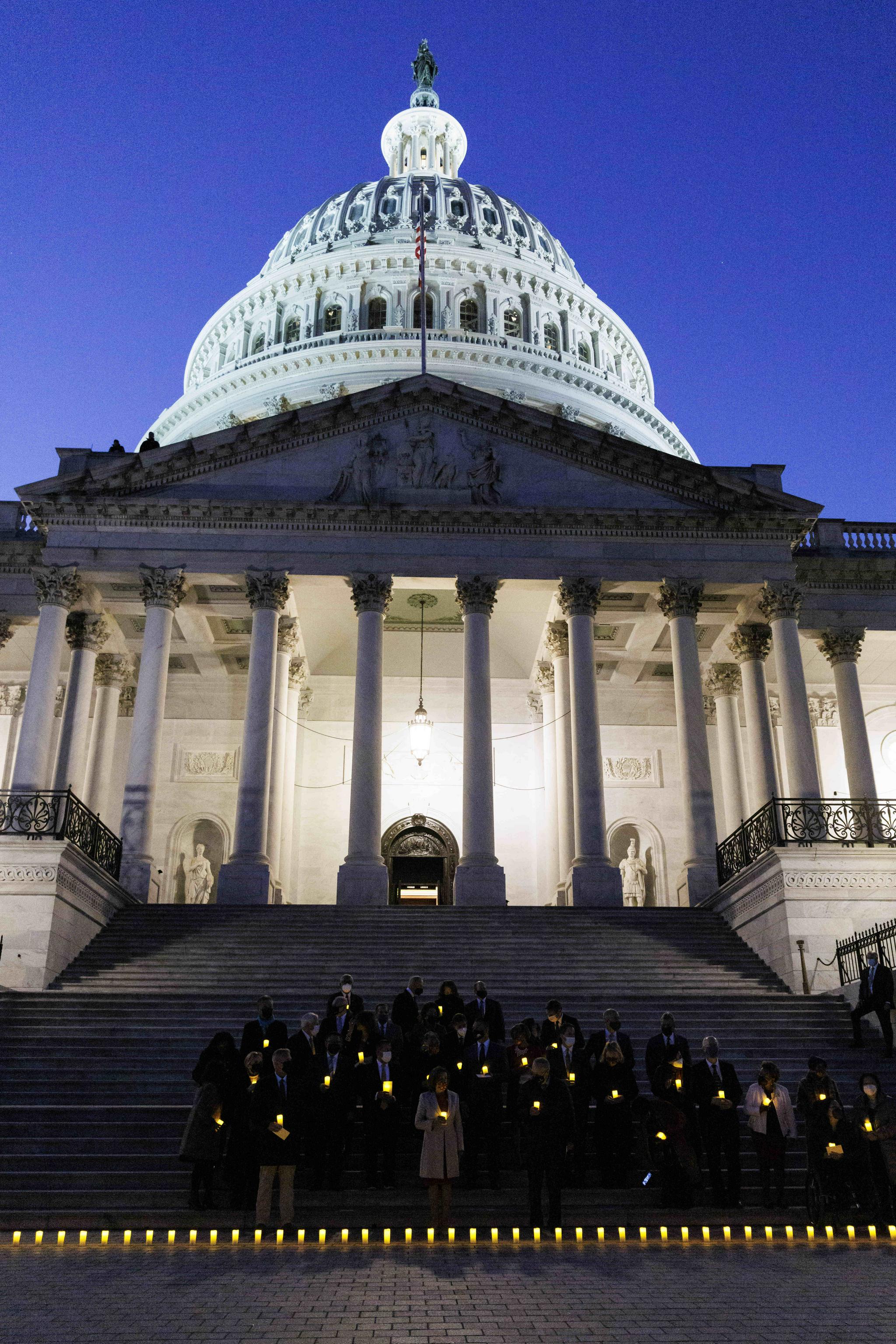 12月14日,在美国首都华盛顿,议员们在国会大厦外的台阶上举行烛光仪式