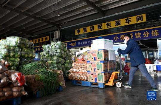 陕西米禾供应链管理股份有限公司的工作人员在搬运蔬菜(12月19日摄)。新华社记者 刘潇摄
