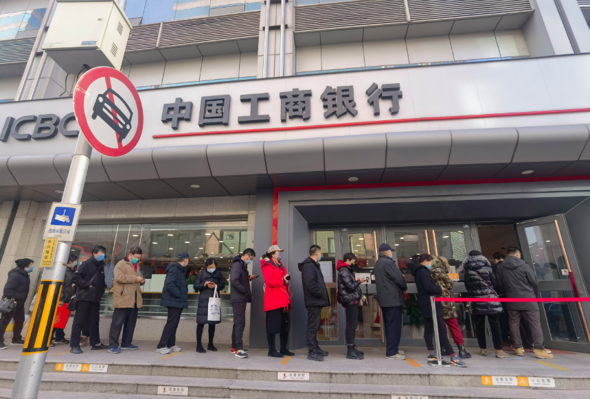 30余位市民正在隔离栏内有序排队,在工作人员提醒下,每一位进入银行的