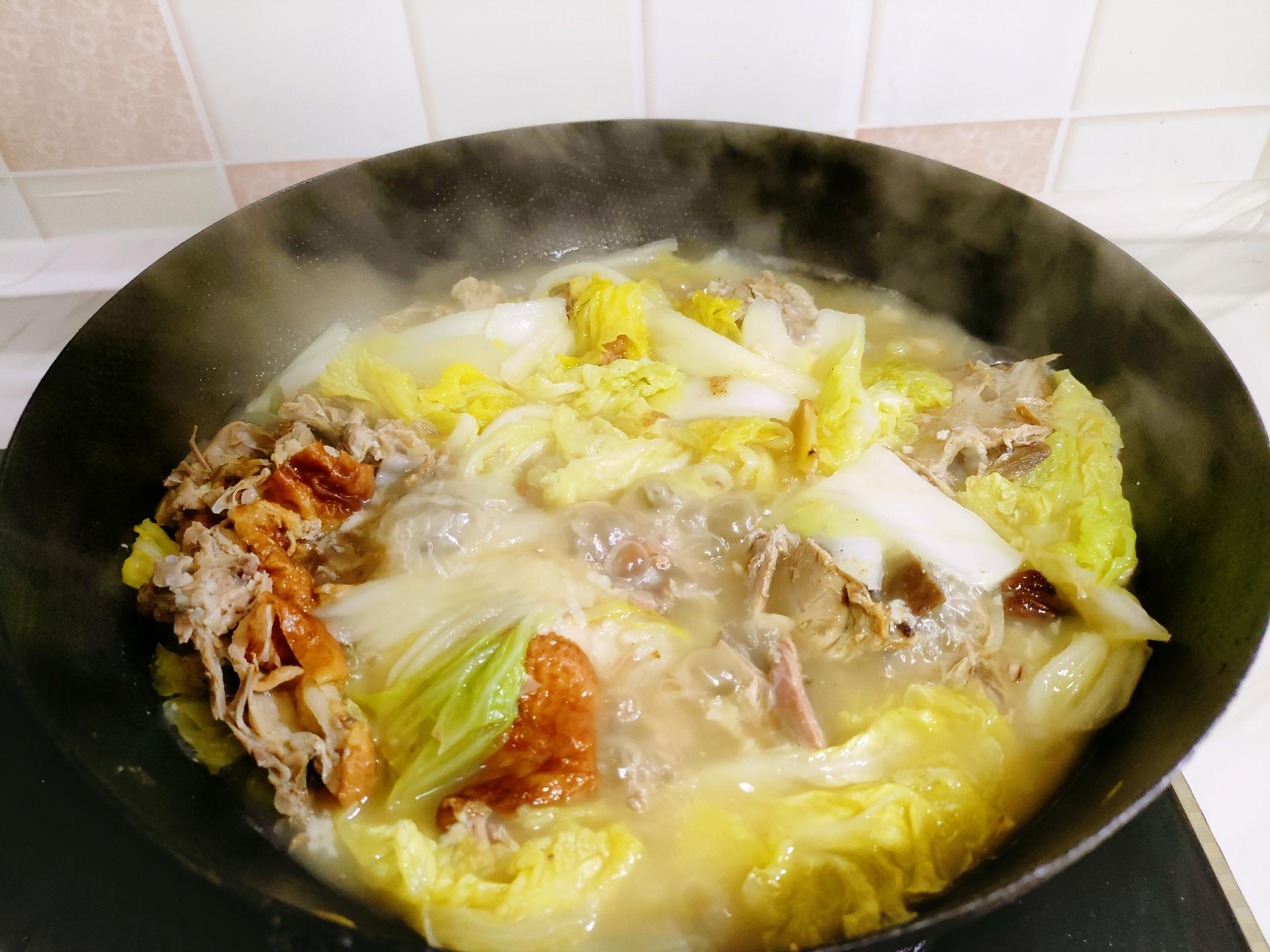 8,把鸭架子连汤带肉都倒入炖锅里,再把白菜捞出下锅,加入盐,白胡椒粉