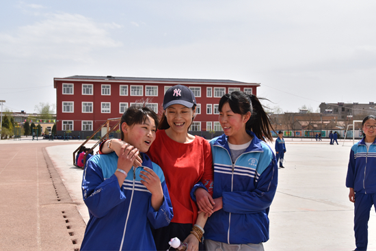 &nbsp;&nbsp;&nbsp;&nbsp;杨海燕(中)在大课间休息时间与三营中学学生