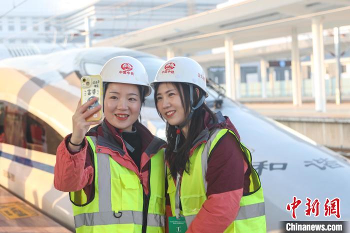 参与京港高铁安九段建设的中铁四局工作人员在列车前合影。刘力鑫 摄