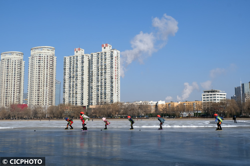 2021年12月25日,小朋友们在辽宁省沈阳市青年公园的湖面滑冰场上