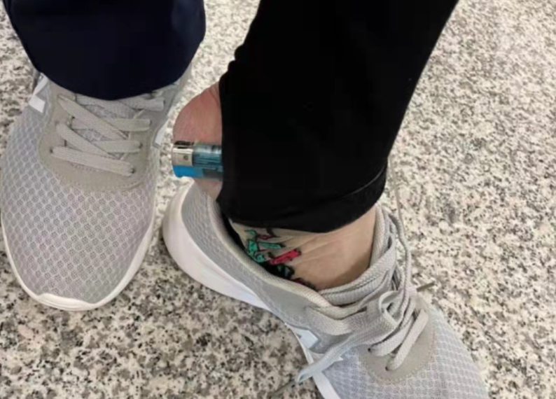 旅客陆某将一枚橙黄色塑料质一次性打火机藏在了右脚脚踝处袜子内,被