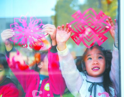 浙江省长兴县幼儿园的孩子们在贴迎春窗花。新华社发