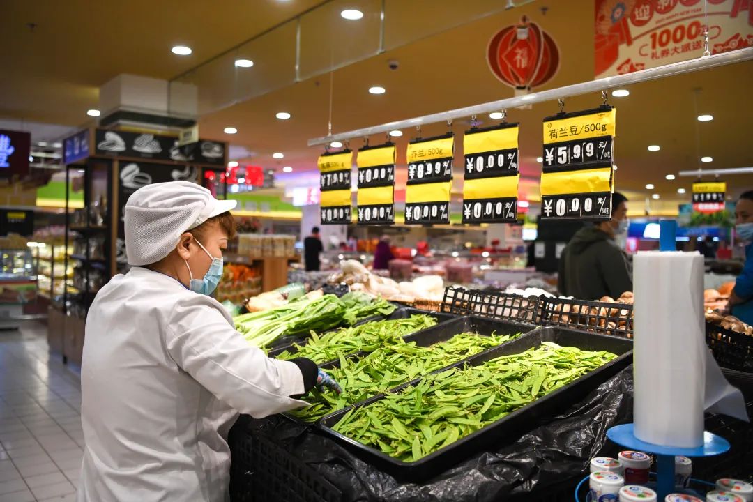 1月25日,工作人员在哈尔滨市香坊区一家大型连锁超市摆放菜品.