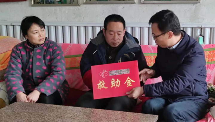 图为济宁市福彩工作人员向受助者韩广安(右二)送上救助金为积极弘扬
