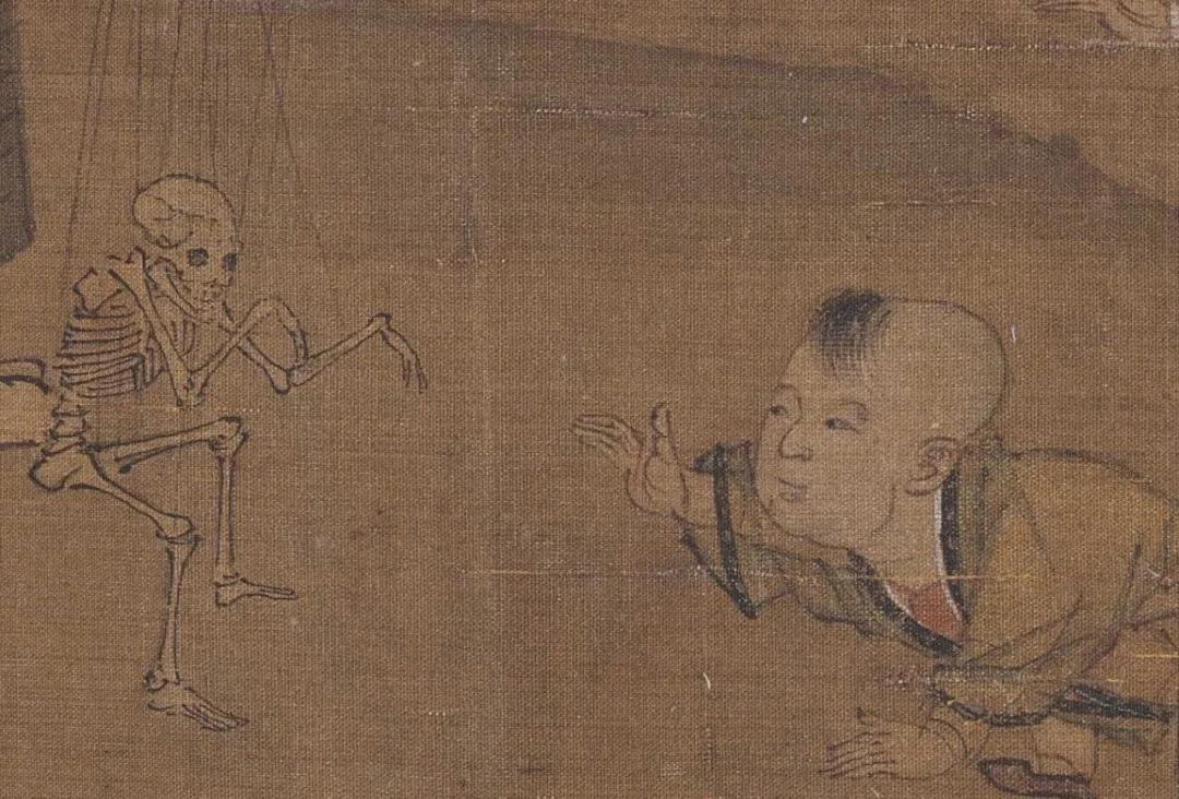 一个小男孩被牵丝骷髅傀儡所吸引,向耍弄骷髅傀儡的骷髅爬去.